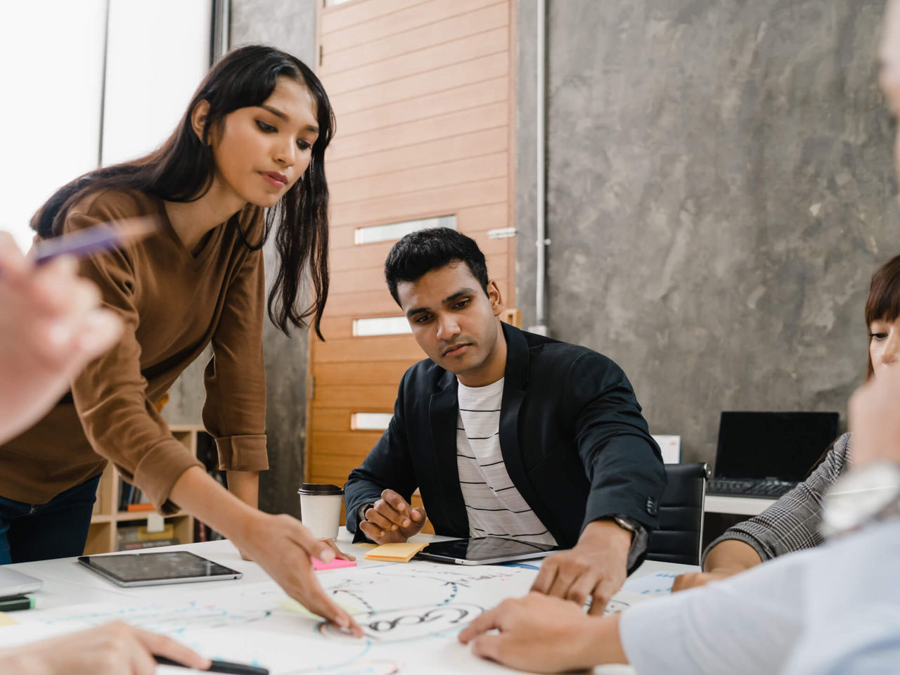 مجموعة من الأشخاص في اجتماع عمل ينظرون إلى رسم.