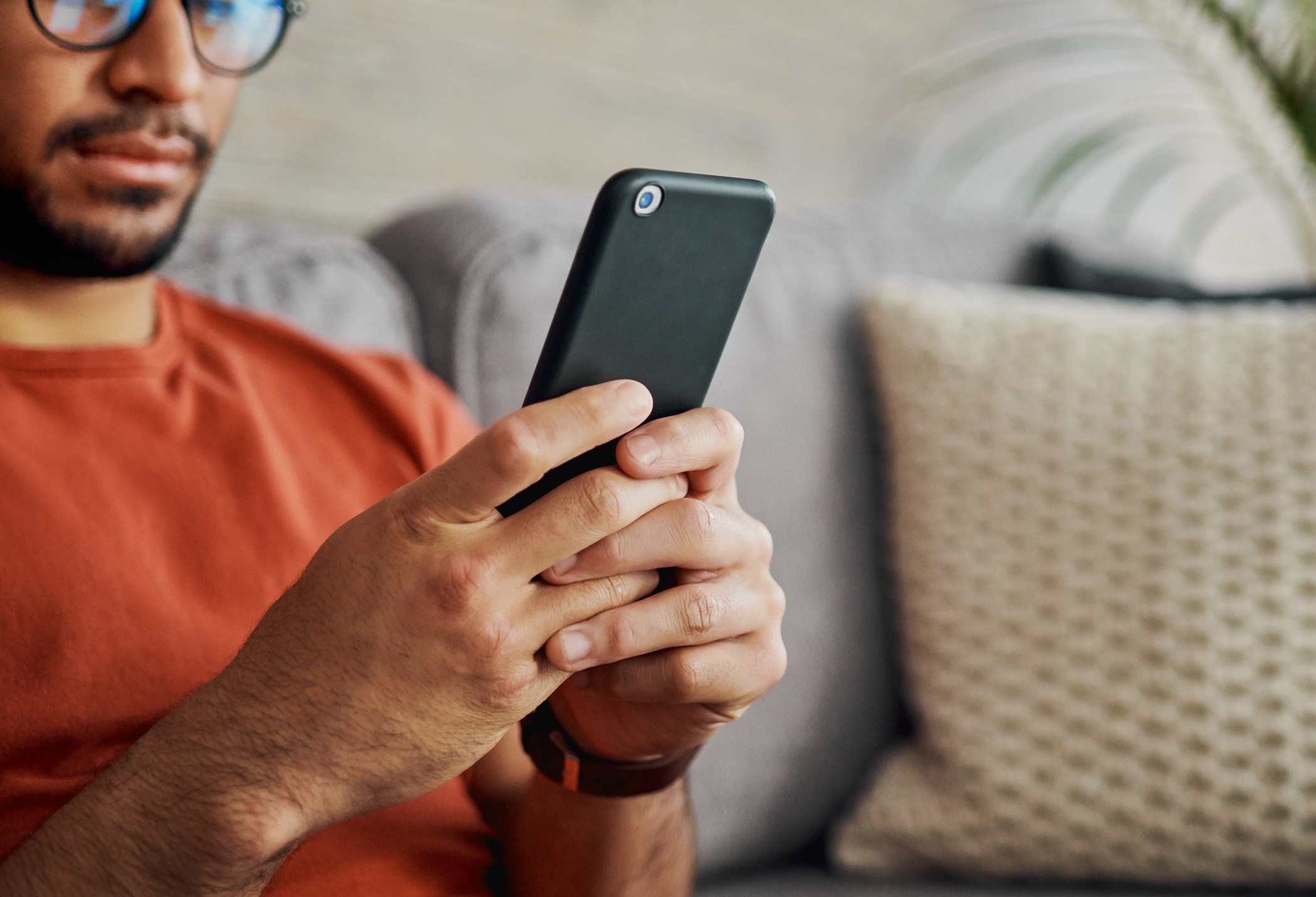 Two people sitting on a couch are looking at an energy bill.
