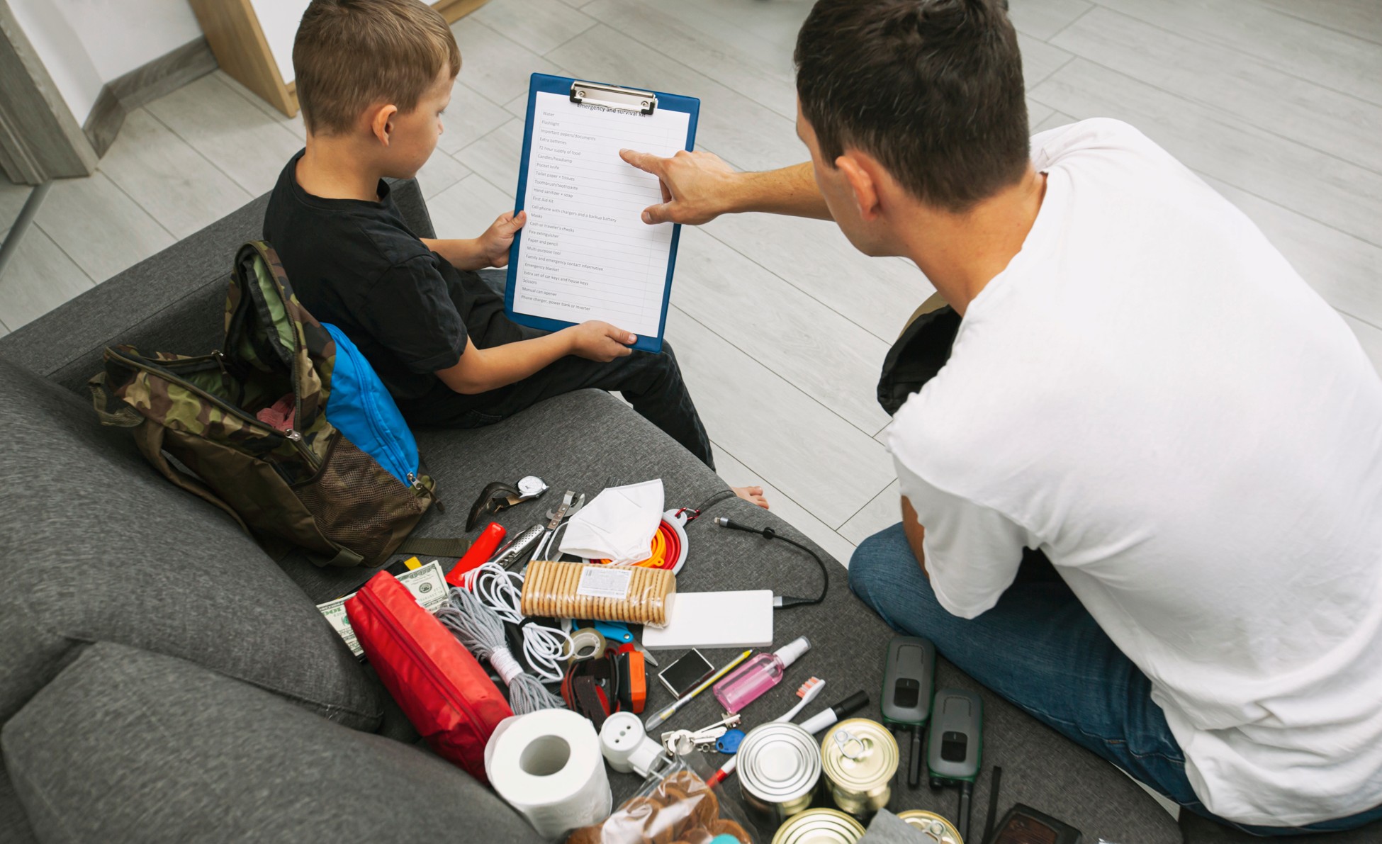 Two people sitting on a couch are looking at an energy bill.