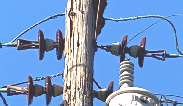 Isang poste ng kuryente na may bitak at punit sa kahoy.