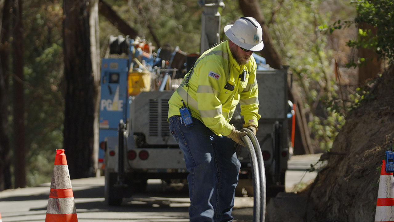 Two PG&E employees inspecting windmills