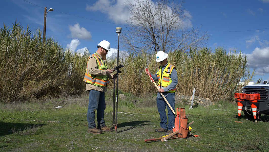 Crew members with surveying equipment.