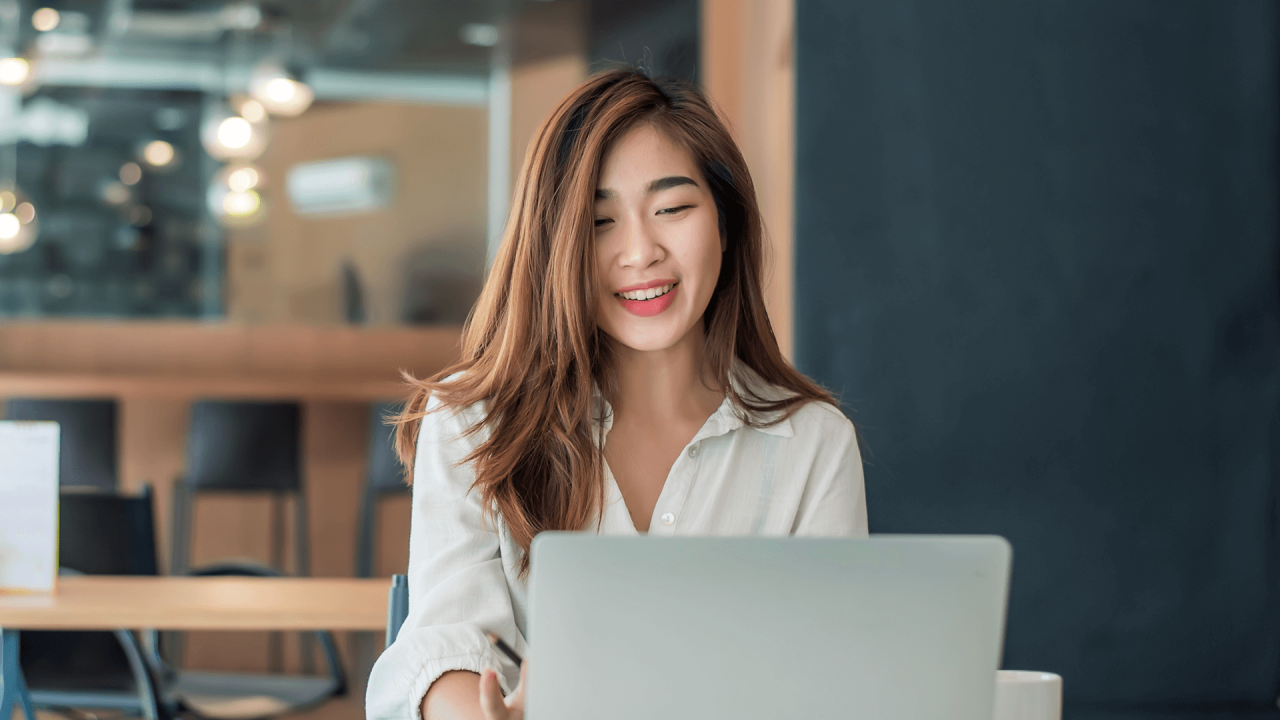 Một người đang ngồi nhìn vào màn hình máy tính xách tay