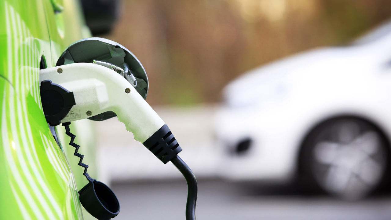 A close-up image of a car and electric charging station.